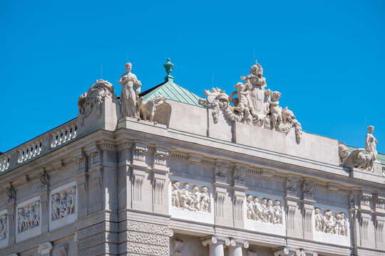 View of the ornate facade and classical sculptures of the Hofburg Palace under a clear blue sky in Vienna, Vienna, Austria.