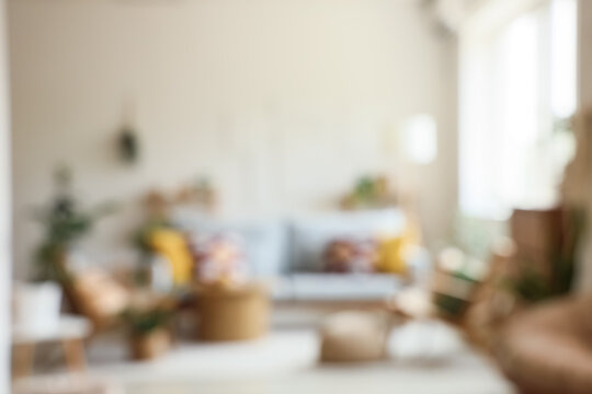 Blurred view of living room with comfortable sofa, table and armchairs