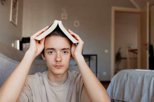 Tired teenager experiencing study fatigue with textbook