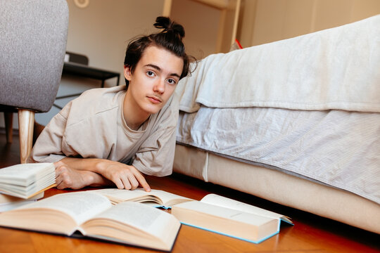 Curious young male student reading books