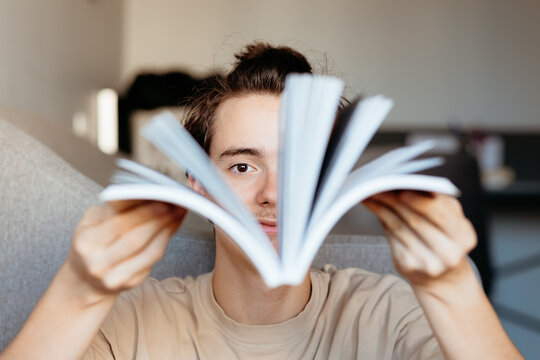 Focused teenage boy exploring open book pages