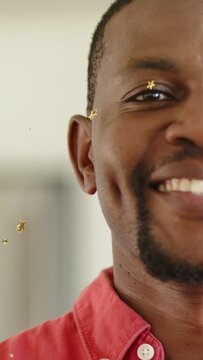 Vertical video: Close-up man reacting as gold confetti appear, smiling and laughing while marketing