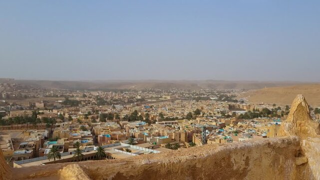 Panoramic view over Gharda&iuml;a, Algeria, a Saharan oasis town surrounded by desert landscape, shimmering heat and distant horizons, capturing everyday life in the desert