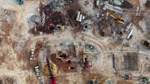 Dirt and steel dominate this active construction site. Machines rumble as workers move through the sprawling dig