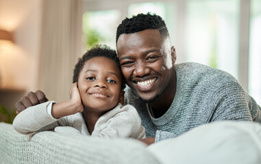 Obraz premium Portrait, dad and happy with child on couch, bonding and black man with son on weekend or childcare. Father, smile and comfortable with kid on sofa, break and connection with single parent in house