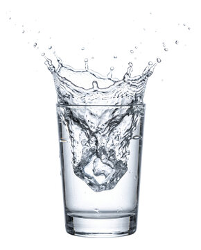 Water splashing out of a glass cup due to falling ice cube
