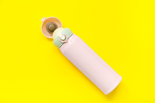 Modern pink thermos on yellow background