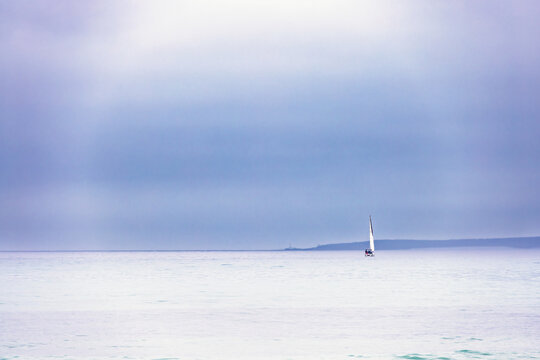Sailboat on the sea with a fogbow on the dark sky