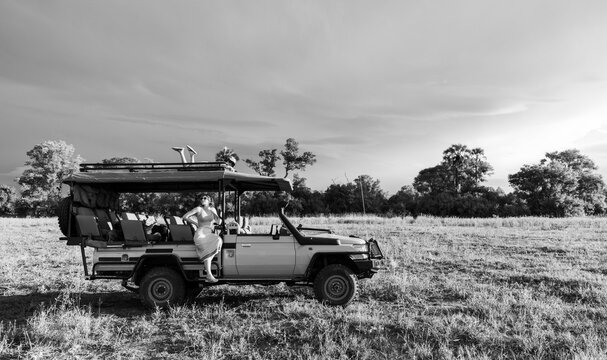 siblings on safari vehicle at sunset, Okavango Delta, Botswana, Africa