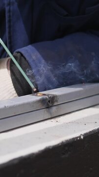Professional Welder Is Working On Steel Beams Amidst Sparks At Construction Site. An Experienced Construction Worker Is Performing Precise Metal Welding While Sparks Illuminate Area