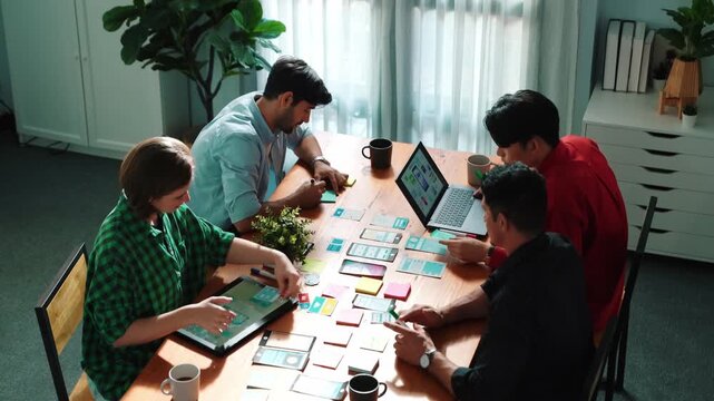 Top view of creative team giving high five to celebrate increasing sales or successful idea. Group of diverse people brainstorming marketing plan by using sticky note while clapping hands.Convocation.