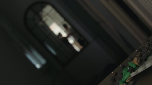 A mirror reflection captures a couple in the middle of a heated conflict, showing emotional distress and physical confrontation. Blister packs of pills are visible in the scene, adding a layer of