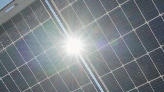Bifacial solar panels generate renewable energy using high efficiency dual-sided technology. Technical view of photovoltaic modules structure at industrial power plant station under bright sun.