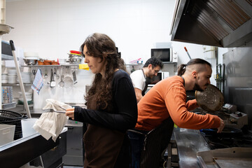 Naklejka premium Kitchen team actively working together preparing food in a professional restaurant setting