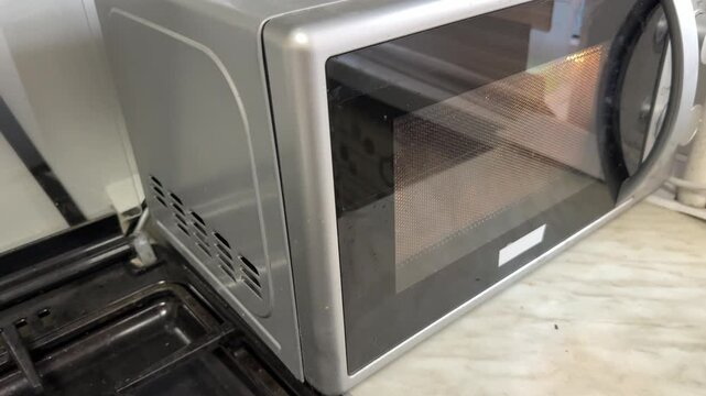 microwave oven control knob and front panel in close up, kitchen appliance interface, home cooking technology concept