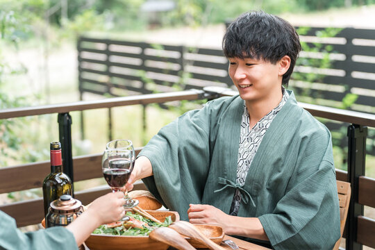 A young Asian couple enjoying a meal on the balcony/wood deck of a traditional Japanese inn/hot spring resort (travel).