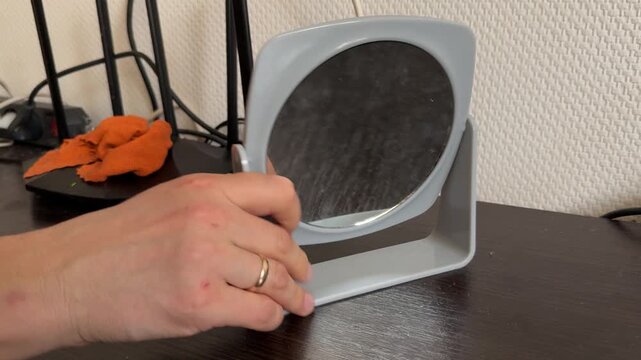 woman adjusting small mirror on table at home, arranging decor, interior styling, daily routine, home organizatio