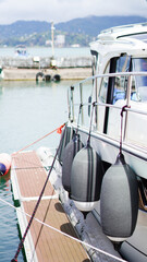 Fototapeta premium Grey teardrop fenders hanging from the side of a luxury yacht at the dock