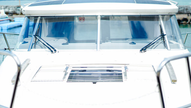 The white bow and windshield with wipers of a modern luxury motor yacht