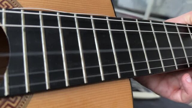 Close up of acoustic guitar body with metal grid background, music instrument detail, abstract composition with texture and shallow depth of field