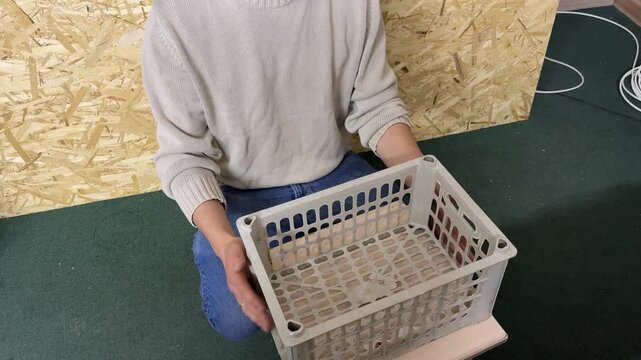 Man holding plastic storage basket, organizing household items, storage and home organization concept in indoor environment
