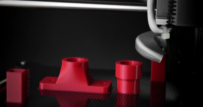 Smooth timelapse of 3D printing of a pipe fitting on a dark background.