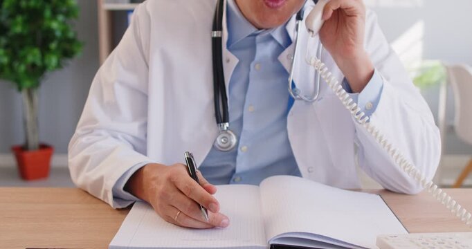 Medical professional at desk, talking on phone and writing in notebook, office professional communication and information management, conveying medical help, patient care or administrative tasks