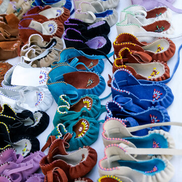 Colorful handmade children's moccasins displayed at pueblo market