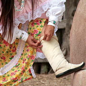 Hand tying traditional moccasin before pueblo dance