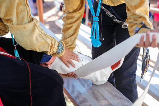 Brother helping sister fasten moccasins before Navajo Nation Fair dance