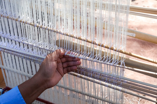 Hands weaving on a traditional Navajo loom