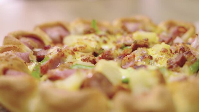 Extreme macro shot of a delicious Hawaiian pizza with golden melted cheese, ham slices, and pineapple. Featuring a decorative stuffed crust and shallow depth of field for a professional look.