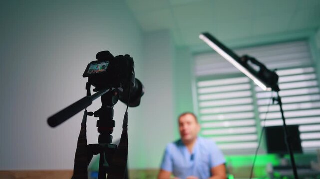 Soffit and camera on tripod directed on the unrecognized man. Low angle view. Medical blog concept.