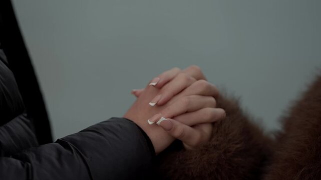 A close-up shot captures a couple holding hands in Paris France The woman's hand is intertwined with her partner's symbolizing love connection and a romantic moment in the city.