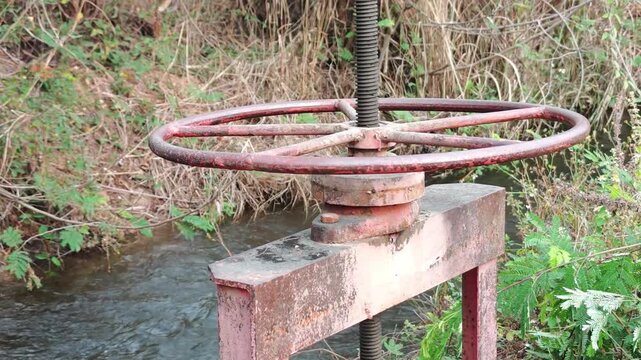 Manual irrigation sluice gate with handwheel and bevel gears in traditional canal
