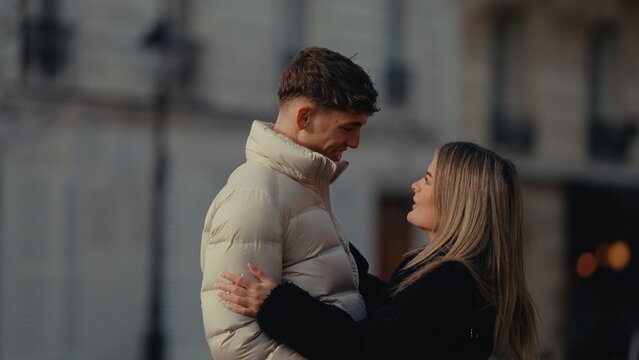 A romantic couple embraces in Paris France sharing a moment of love and affection They are wearing winter coats and enjoying their time together in the city.