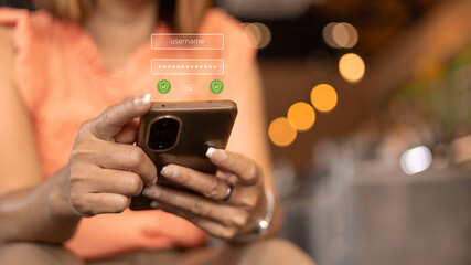 Naklejka premium A person is sitting at a table in a cafe using a smartphone. The screen shows a login screen with username and password fields. It is daytime and there are blurred lights in the background
