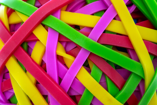 Intertwined colorful rubber bands forming a dynamic and flexible background pattern