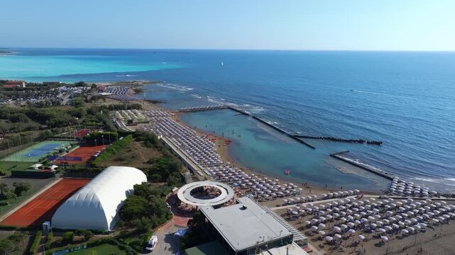 rising aerial showcasing world-class athletic playground and the warm blue beaches of Castiglioncello, Italy, Tuscany