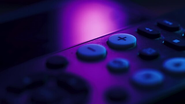 Macro view of finger pressing channel button on remote control