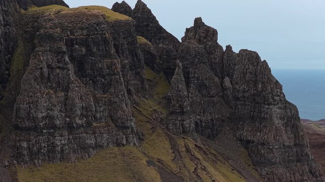 Aerial view moving downwards along the rugged and dramatic basalt rock formations of the quiraing on the isle of skye in scotland