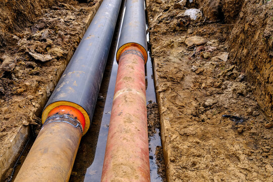 Replacement of old underground heating pipeline with new insulated pipe in construction trench