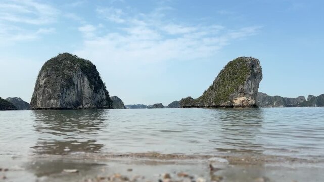 scenic limestone karst islands rising from calm waters in halong bay vietnam during a bright sunny day