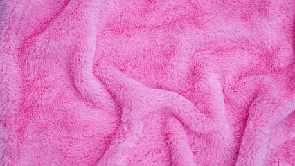 Soft pink fabric lays on a flat surface, showing texture and folds during the afternoon light © Fleuronica