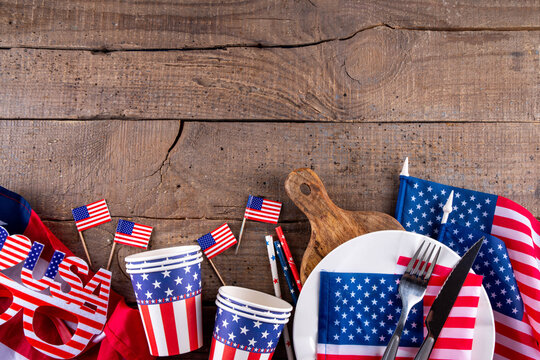USA patriotic table setting with american flag, plate and decoration in national flag colors on white background. Independence Day. Happy Memorial Day dinner menu background top view copy space