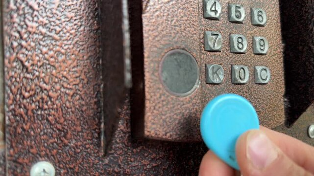 Person pressing intercom keypad button close up outdoors, entering code, access control system, security technology concept