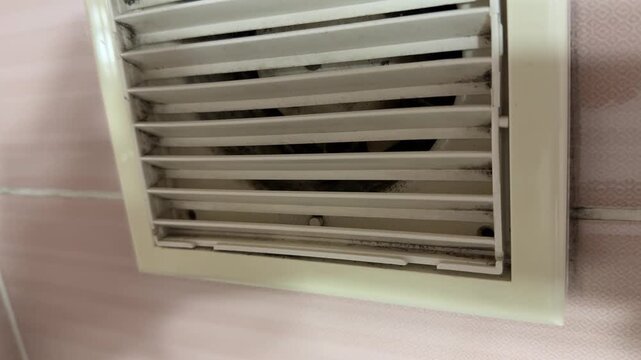 bathroom exhaust fan grille in close up, ventilation system removing humid air and odors, home air circulation concept