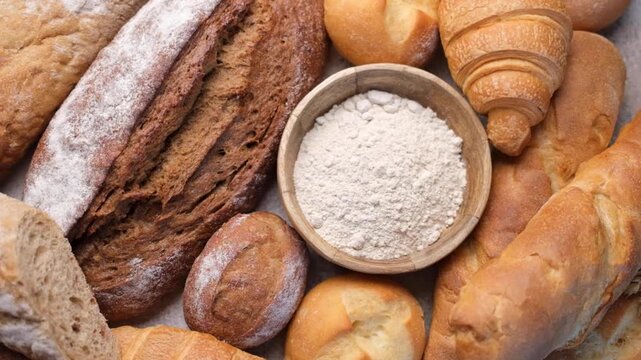 Freshly baked bread assortment and flour rotating