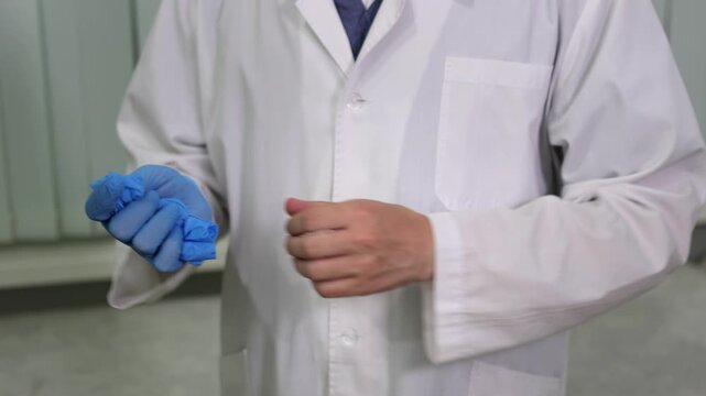 A medical worker. A man in a white coat. Disposable gloves. Slow motion video. High quality 4k footage