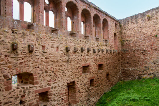Interior ruins of Saint Ulrich castle with stone walls and romanesque arched windows. Historic medieval architecture made of pink sandstone in Ribeauville, Alsace, France.